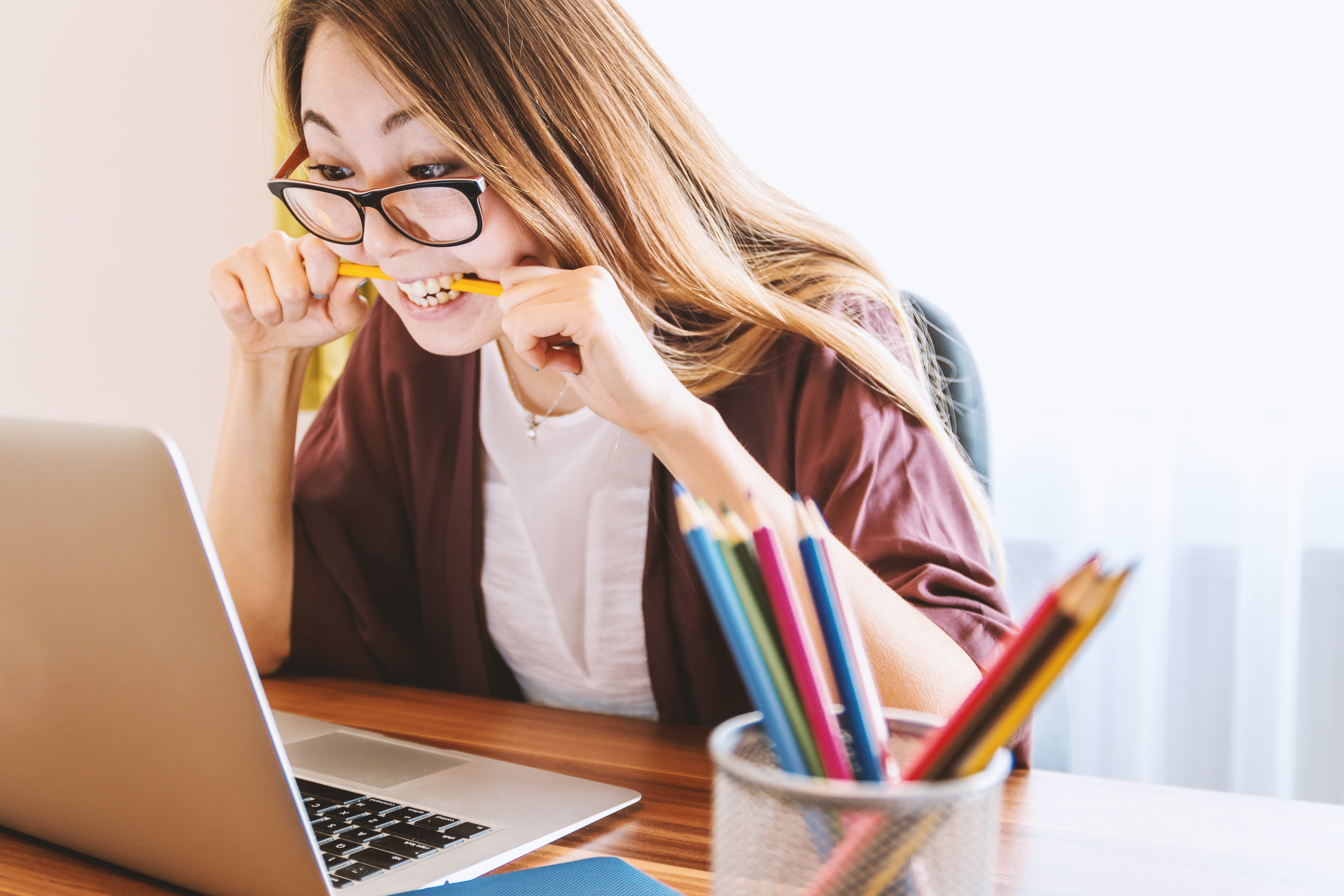 School biting pencil doing school work.