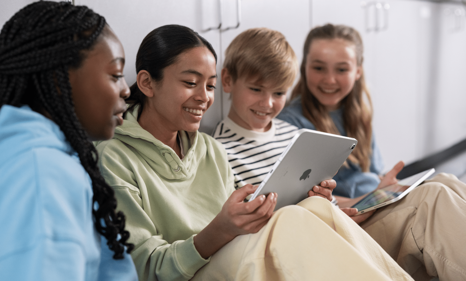 School pupils sat together around an iPad
