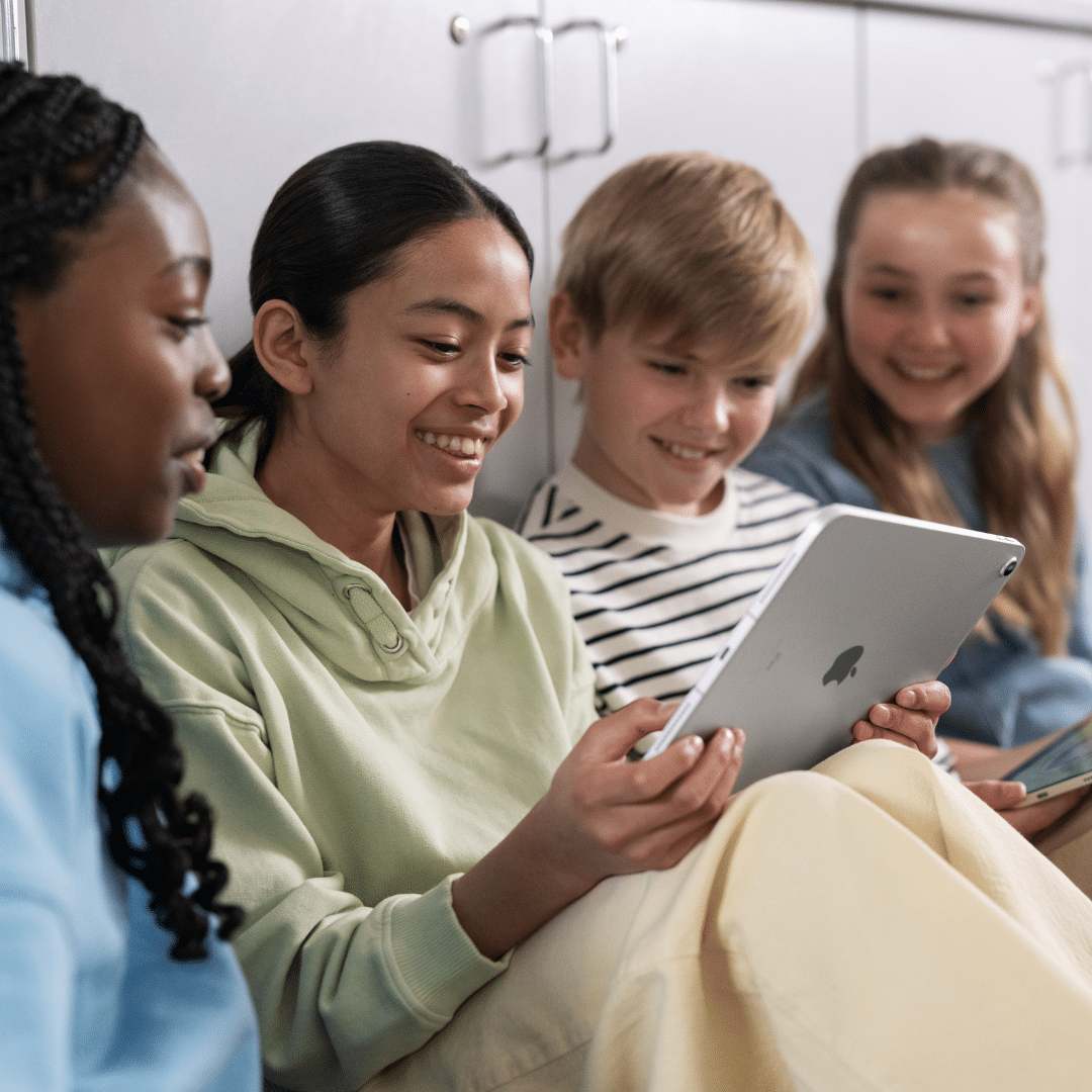 School pupils sat together around an iPad