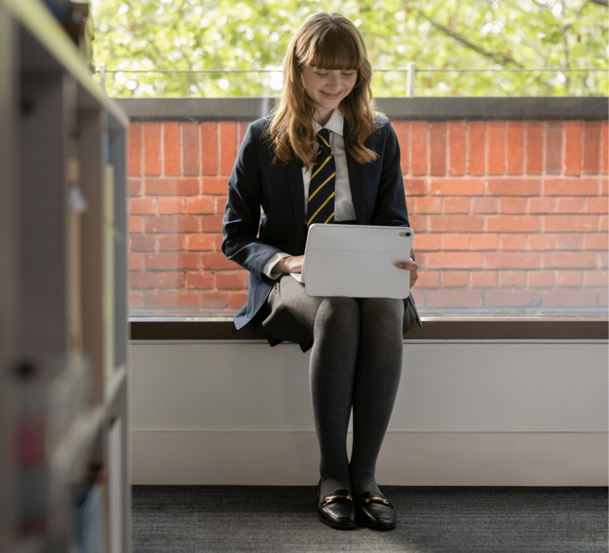 Female student sat working on her iPad