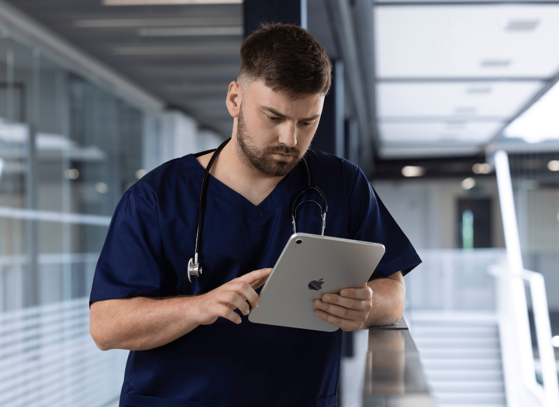 Doctor checking iPad on a hospital ward