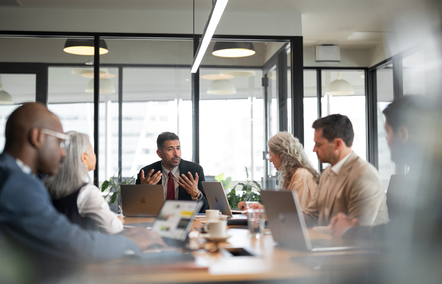 Group of Higher Education Professionals discussing work with their workplace devices